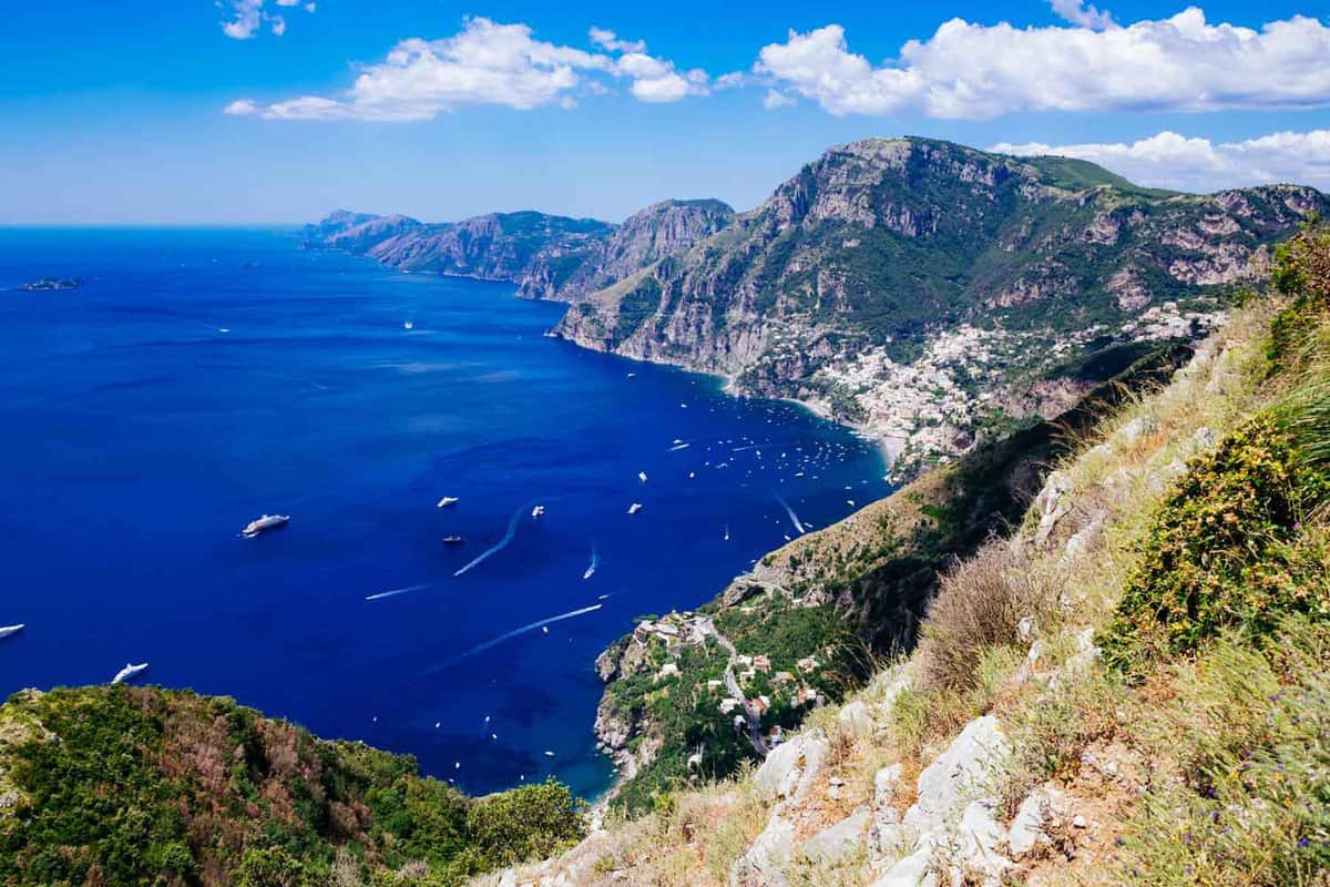 Positano and Amalfi Coast from Sentiero degli Dei - The Path of the Gods hike, showing rugged cliffs on blue Mediterranean Sea