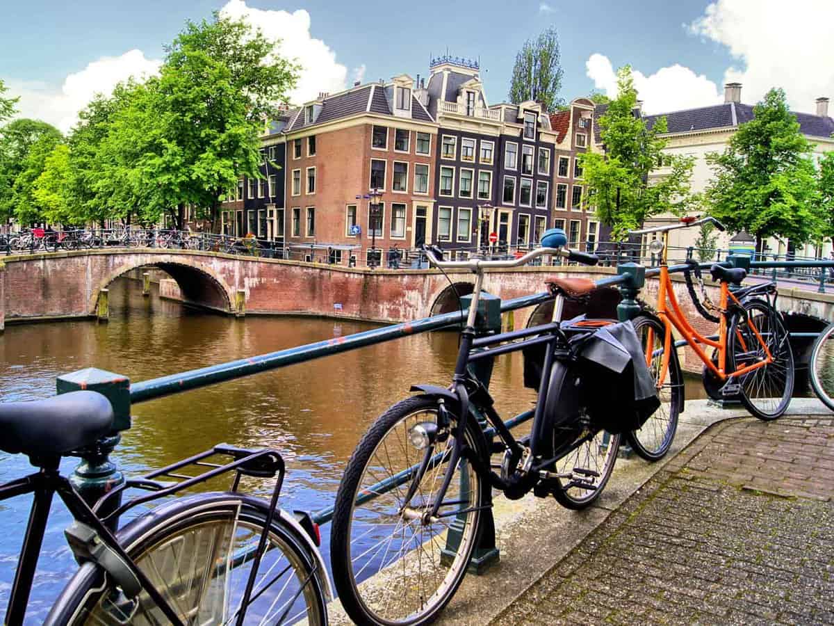 Bikes lined up besides a canal during the daytime