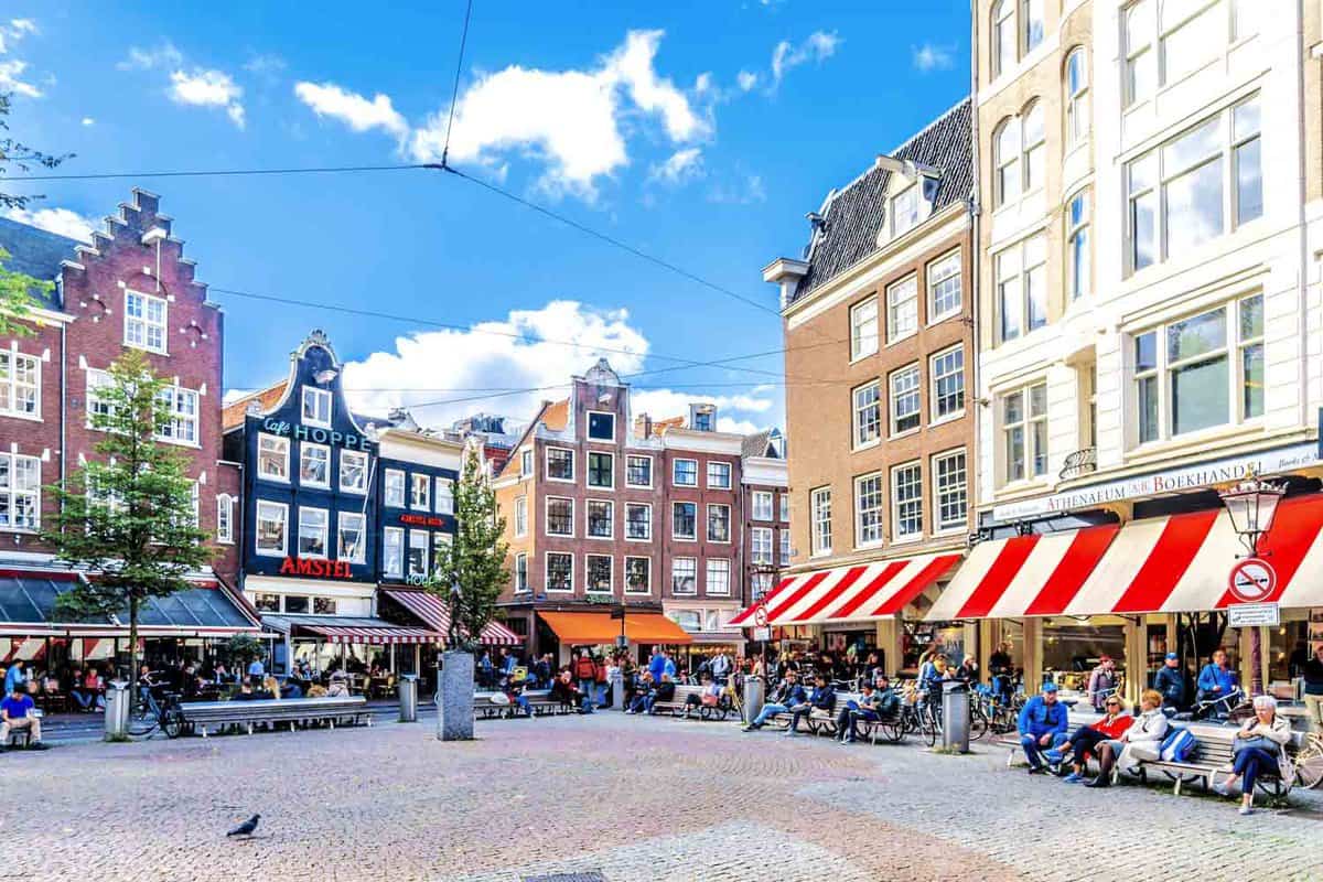 Tourists gathering at the Spui Plein (Spui Square) surrounded by historic houses with ornate gables in the historic center of Amsterdam