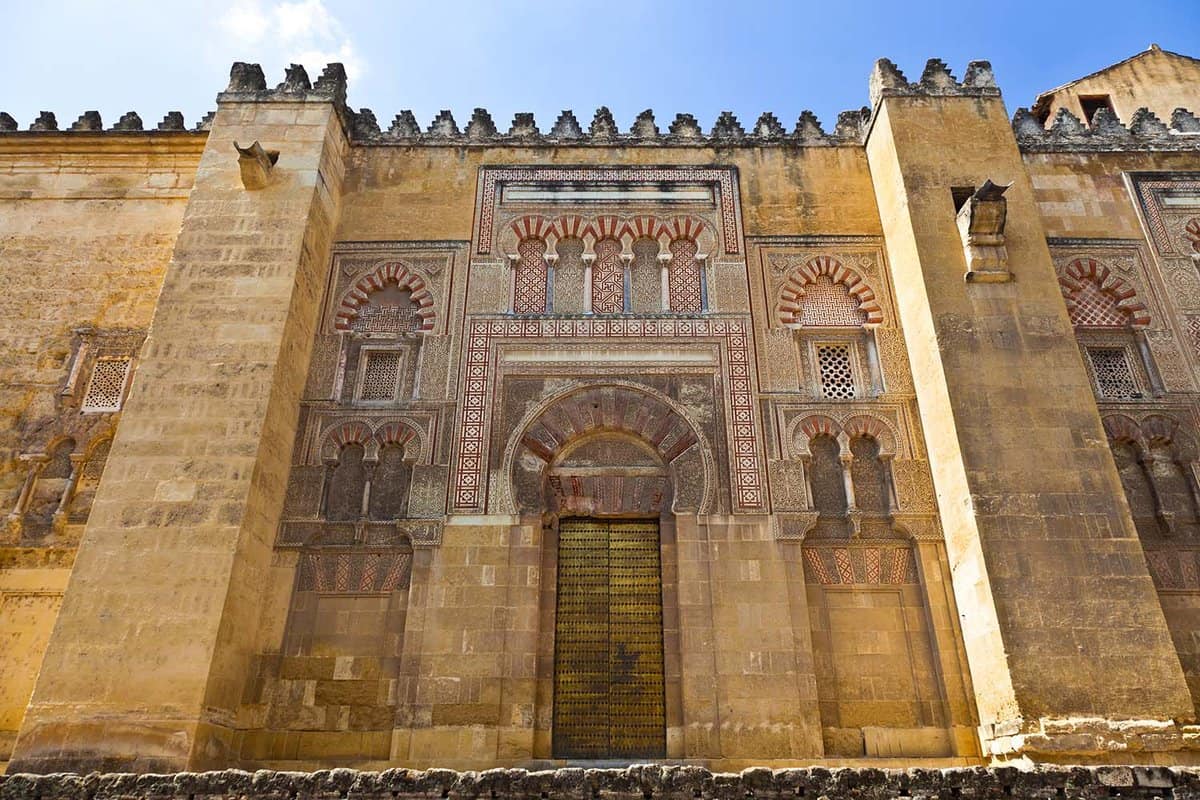 Exterior facade of the Mezquita with intricate moorish design and golden stonework