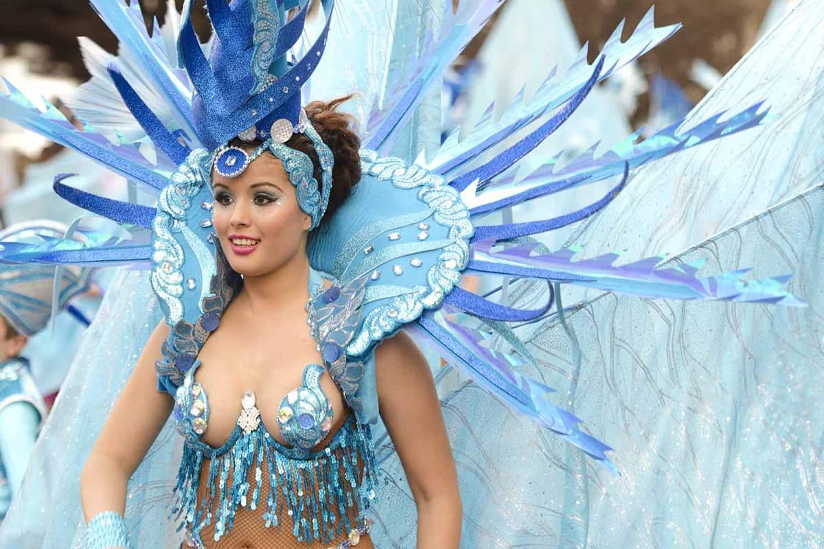 A samba dancing with a large headdress and costume in light blue