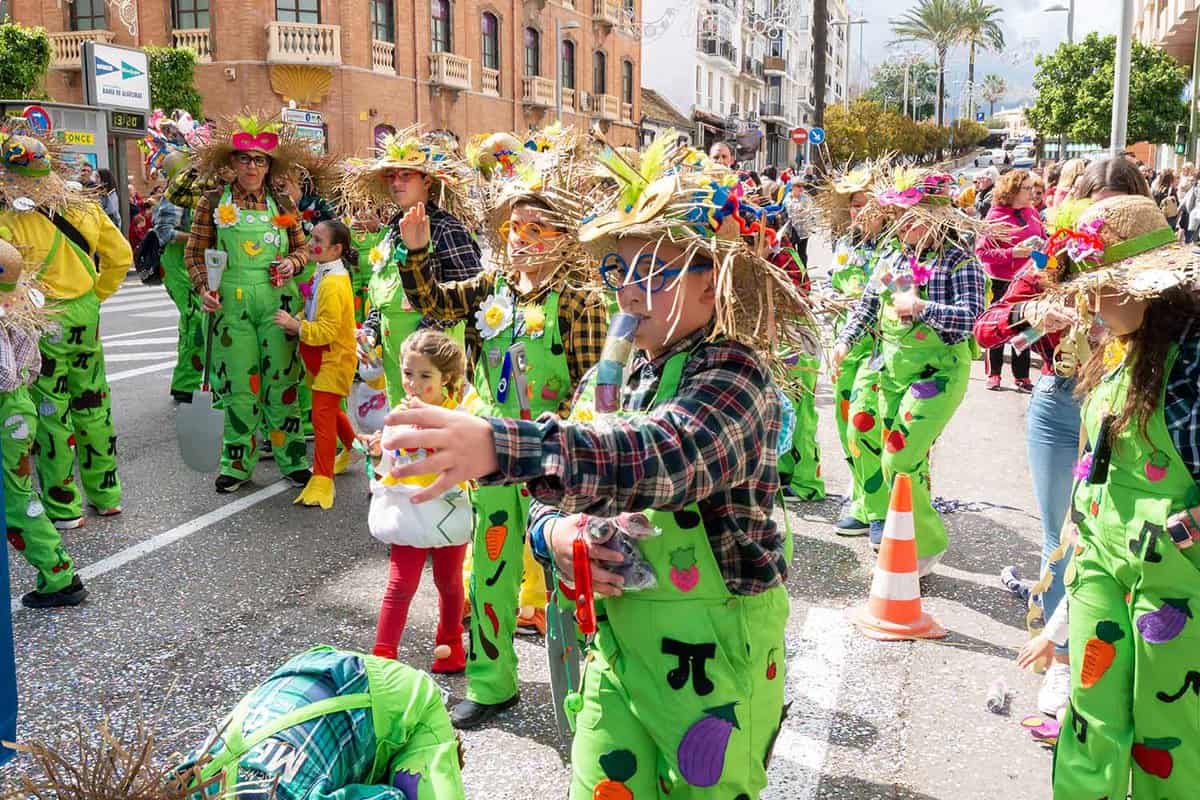 Carnival participants in colourful green dress celebrate in the street