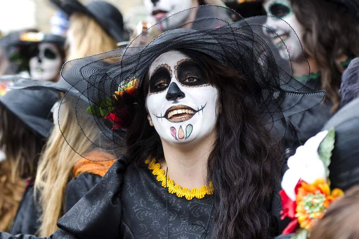 Carnival goers dressed in black with skull face paint