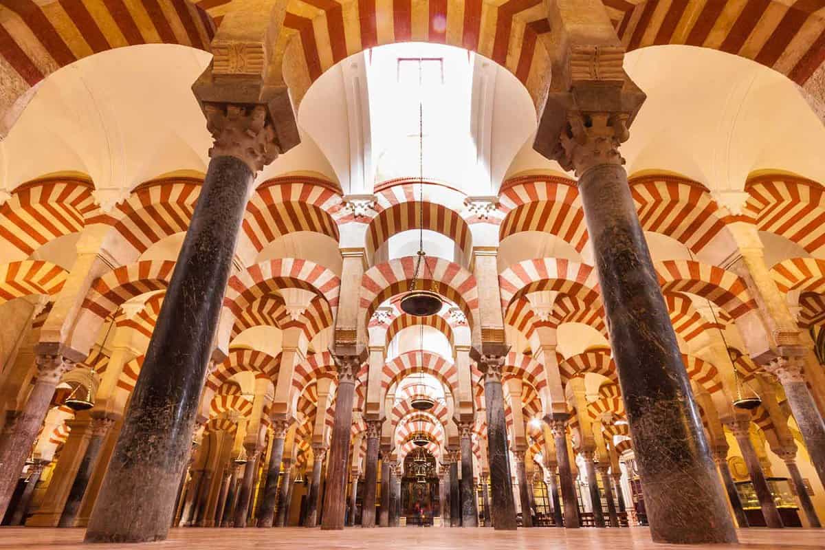 Interior of the mosque-cathedral, a room full of rows of archways patterned with stripes