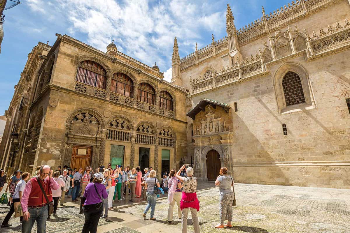 Tour groups wait to enter the intricate stone building