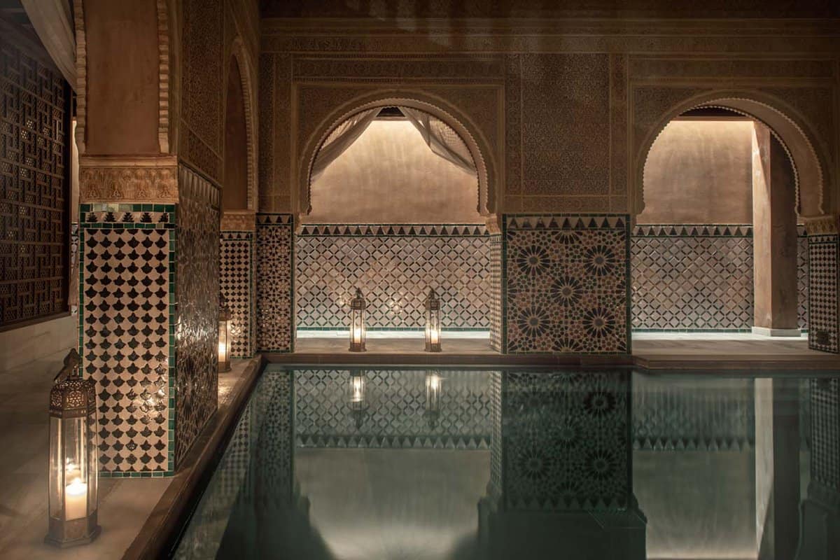 Interior of the dimly-lit hammam, showing candle-lit pool