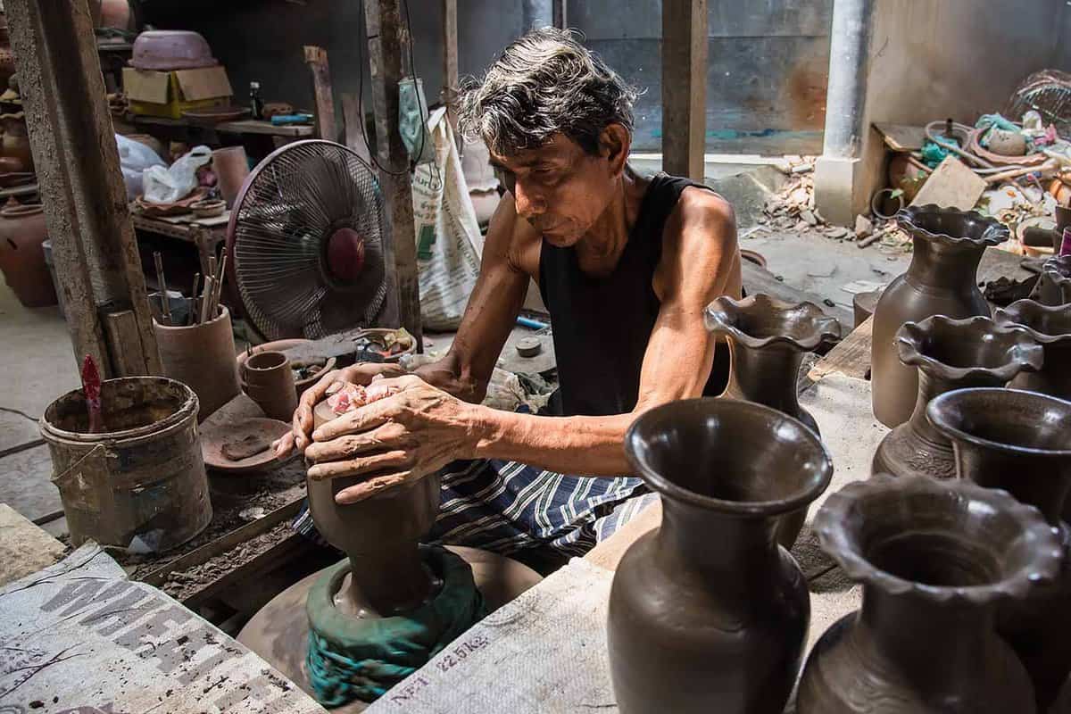Male potter making a jar on a pottery wheel