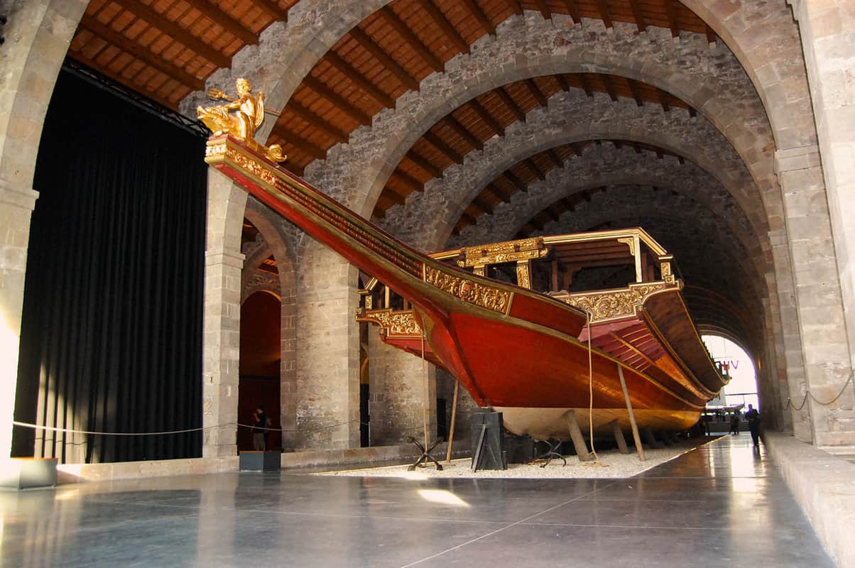 Beautiful gold and red long boat housed in a large warehouse room