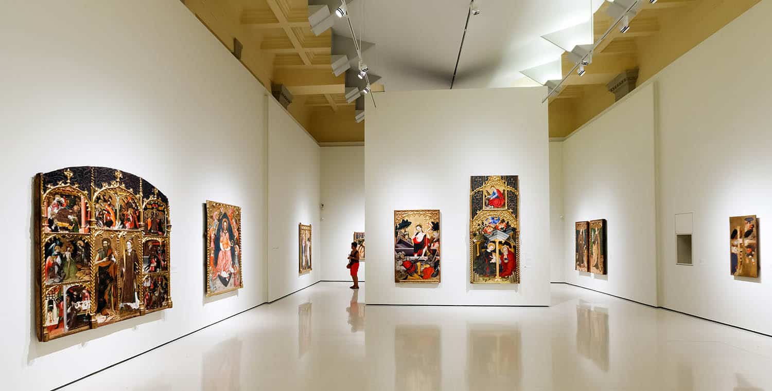 Interior gallery with white walls and colourful paintings