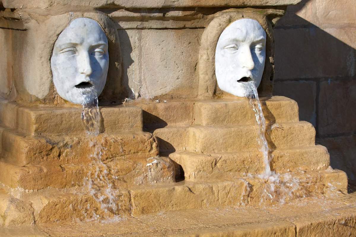close up of strange fountain with two heads spitting water out