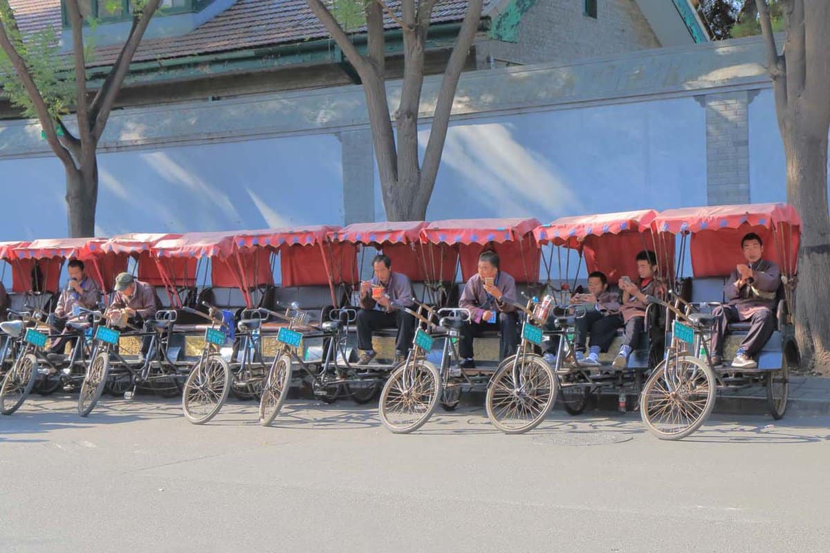 Row of rickshaws and riders waiting for tourists at Houhai Lake