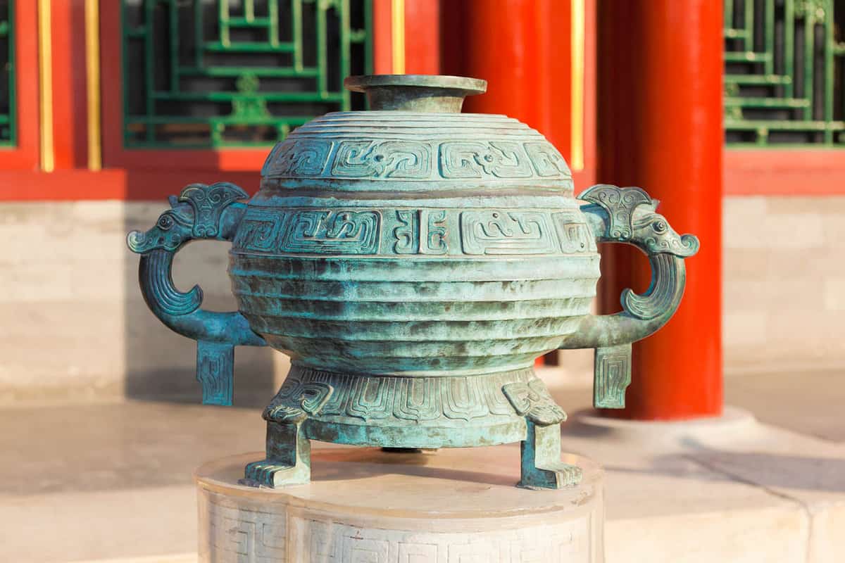 a green urn outside of the temple