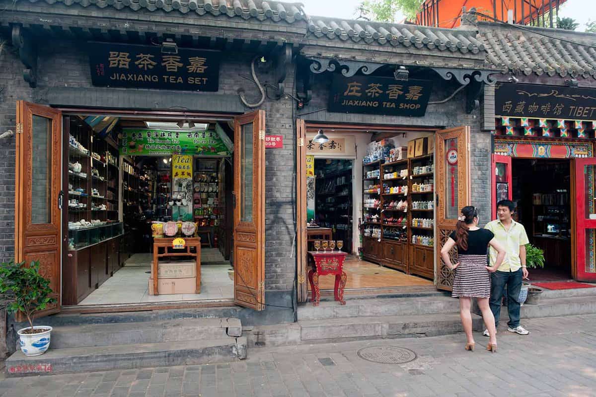 Chinese chat outside stores on the main street of the Jingyang Hutong on June 19, 2012 in Beijing. The Hutongs provide a glimpse of life in Beijing centuries ago.
