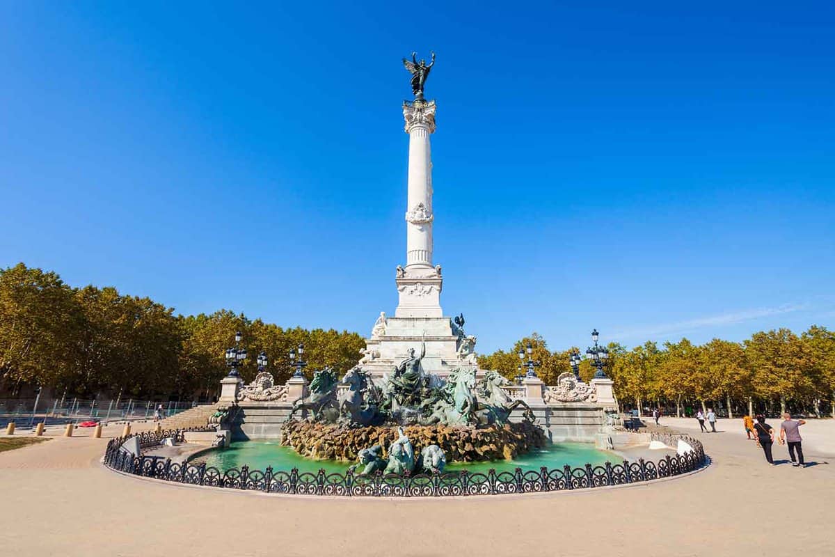 A 43m high white column monument in an empty square, with grandiose fountain at its base