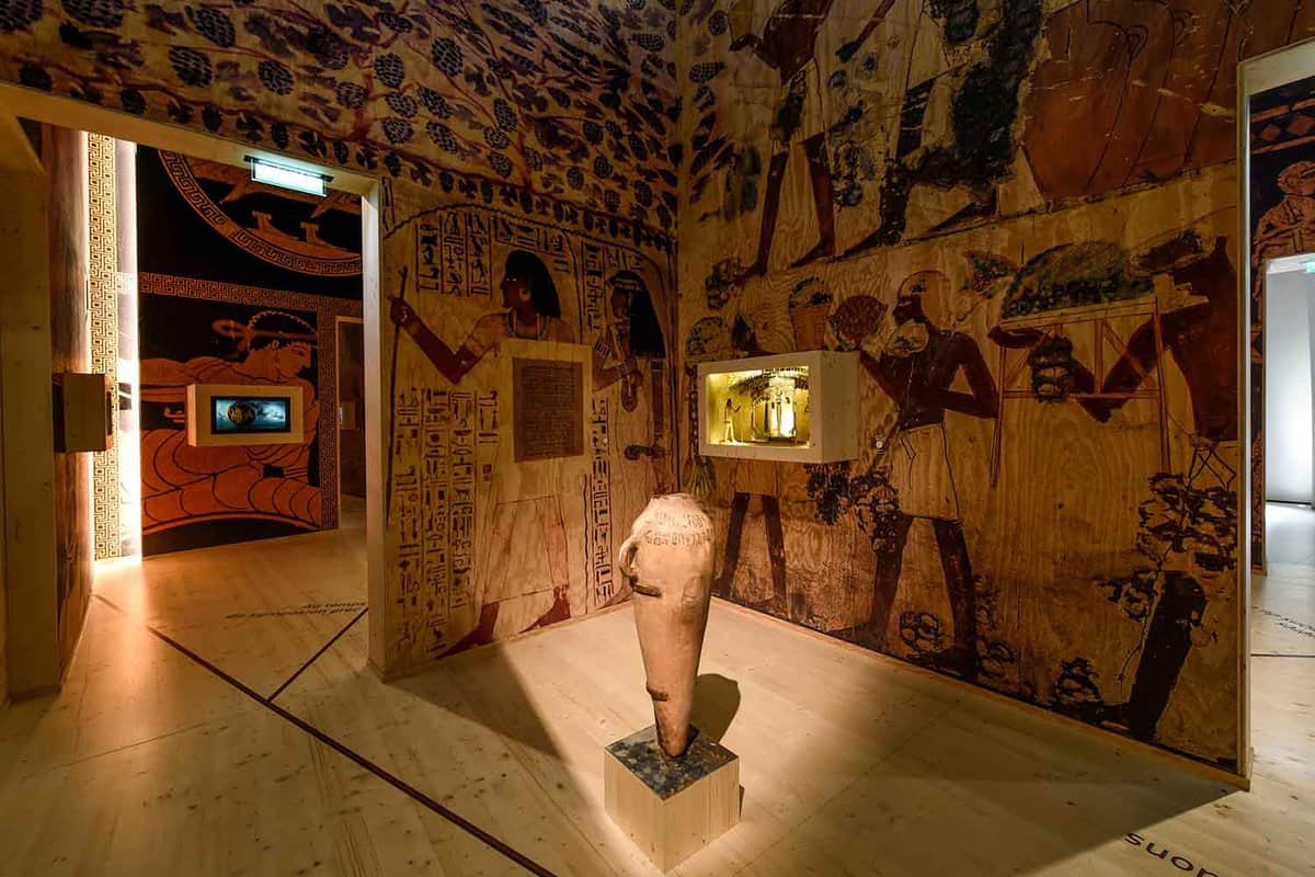 Inside wine city. The walls are painted with ancient-looking iconography and there is a vessel on display