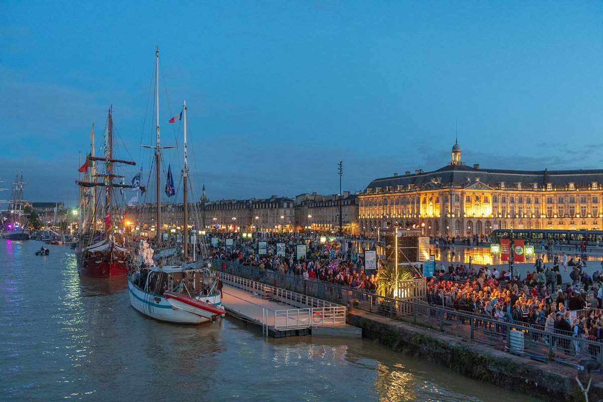 Bordeaux's port at night with crowds on the banks