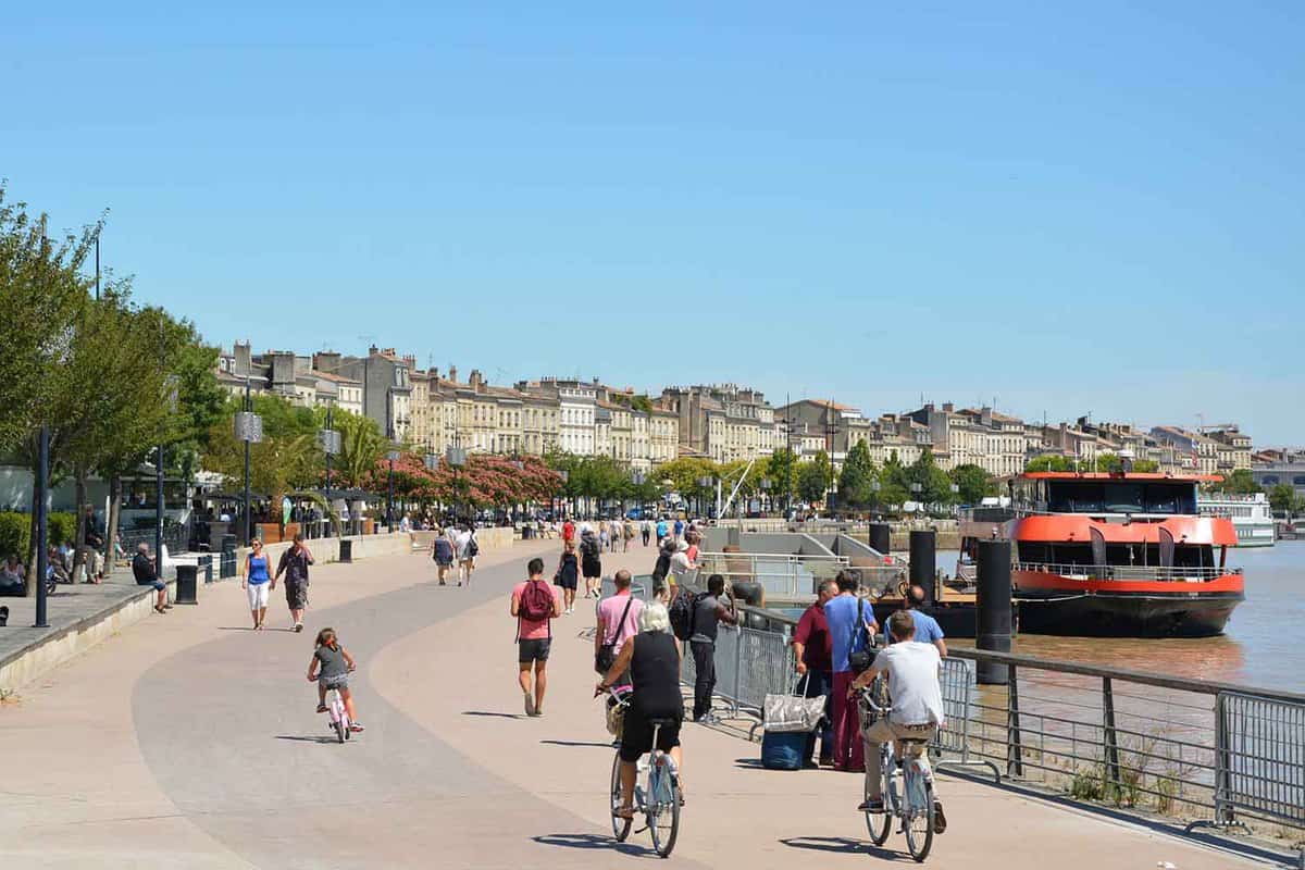 Cyclists and pedestrians travel down a path beside the river