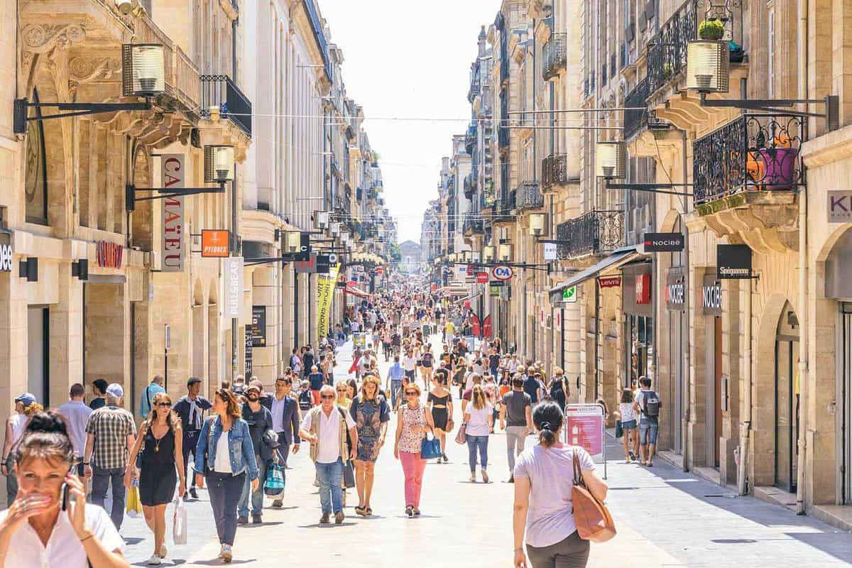 People walk on Rue Sainte-Catherine in center of Bordeaux city. The Rue Sainte-Catherine, a 1.2 km long pedestrian street, is the main shopping street in Bordeaux