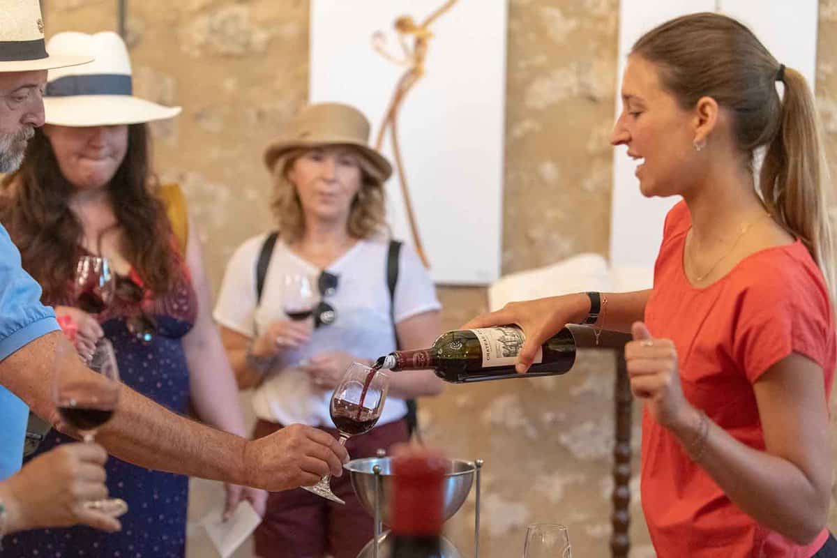Tourists having wine tasters poured from a bottle