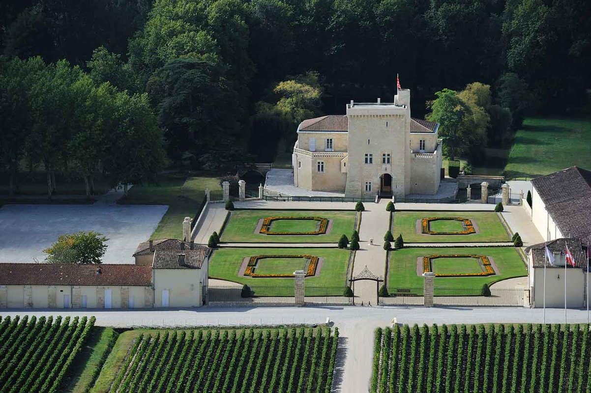Exterior of a beautiful chateau with wine fields in front