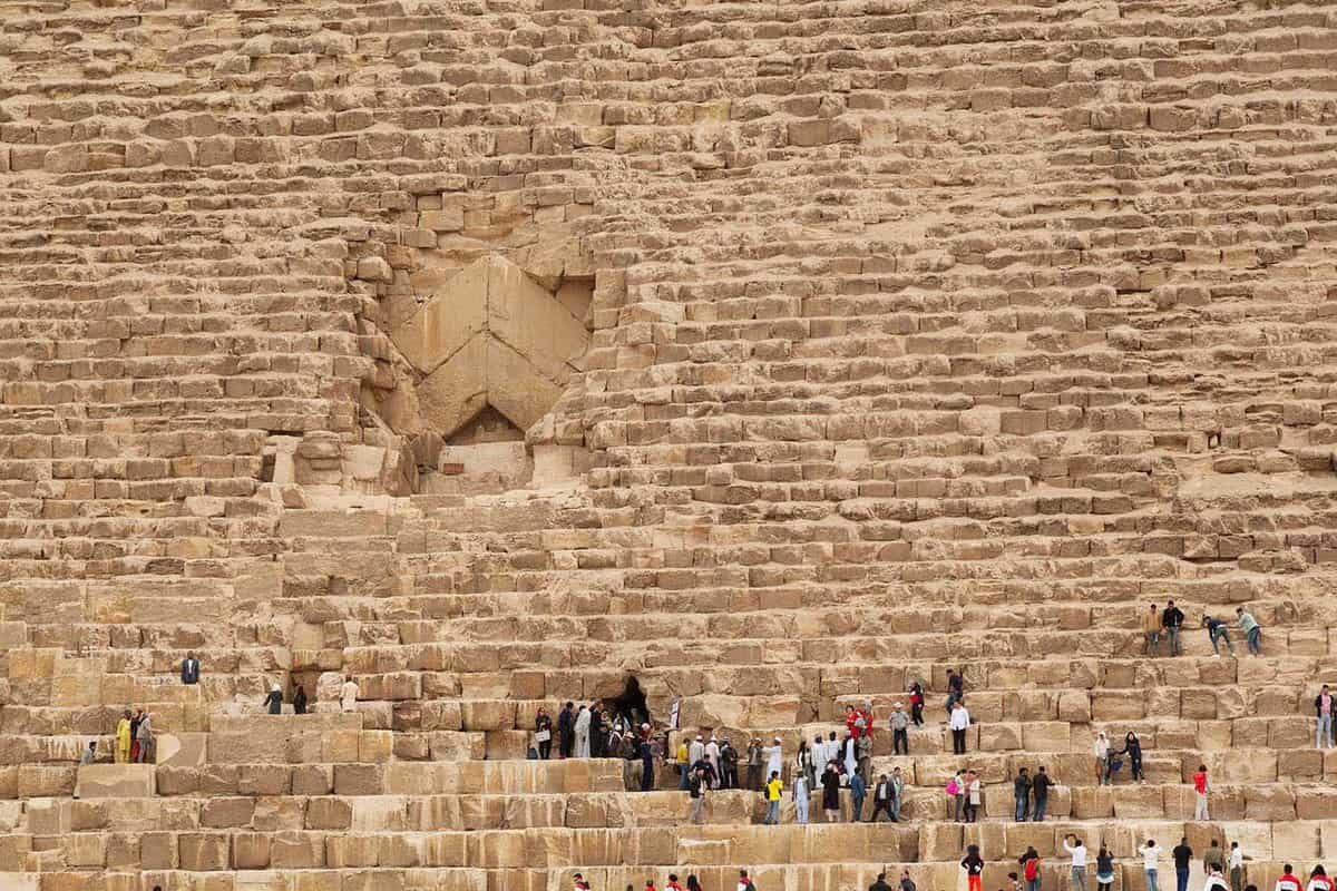 tourists climbing on the blocks of the Great Pyramid