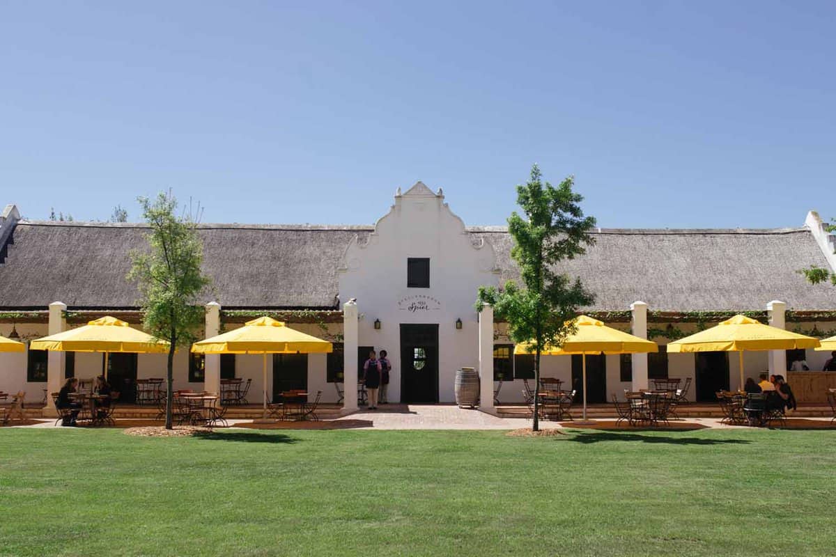 Exterior view of the front with dining tables and yellow parasols.