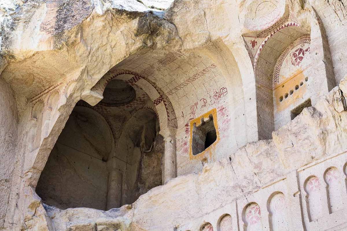 An entrance to a building inside a natural rock formation. Taken from below.