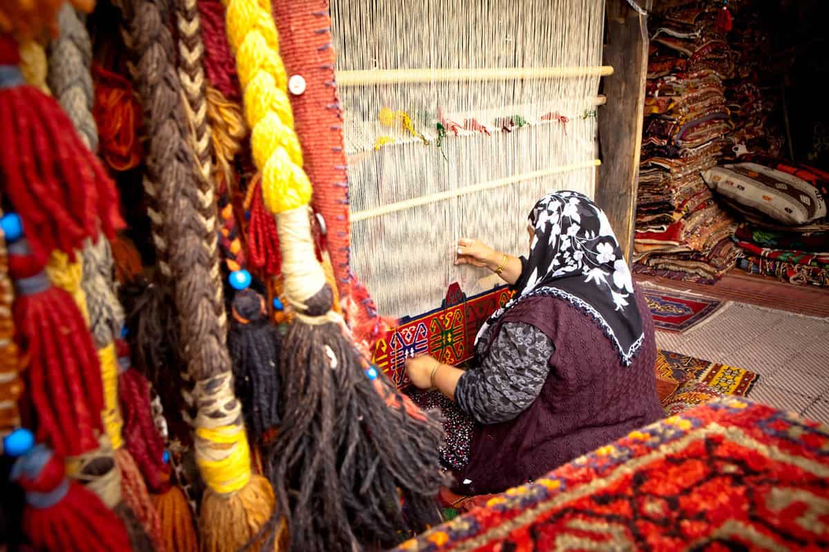 A woman weving a carpet.