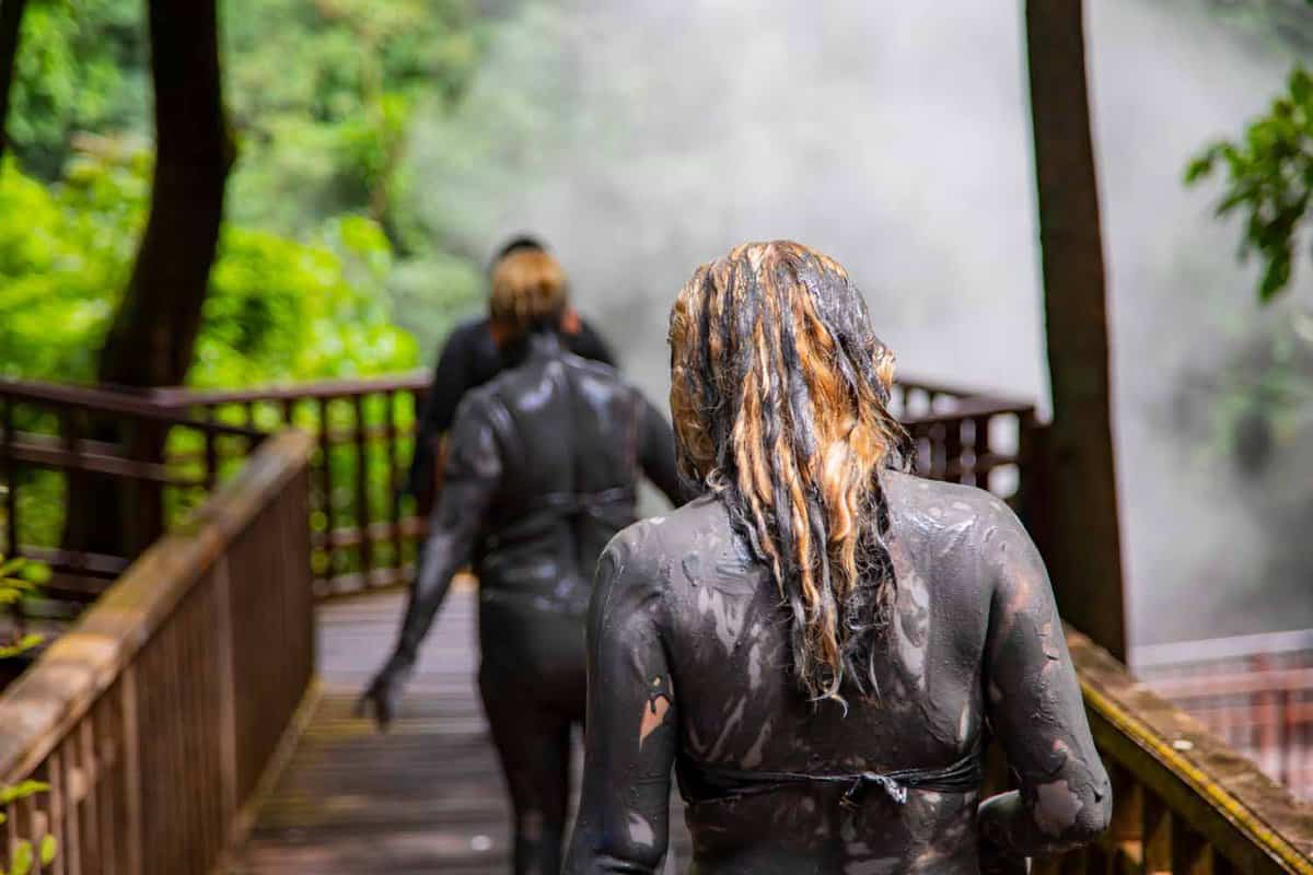 People smeared with healing mud go down to the hot springs