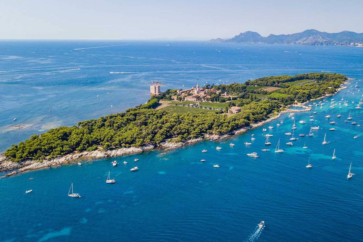 Aerial drone shot view of yachts between Ile Sainte Marguerite and Ile Saint Honorat in mediterranean sea