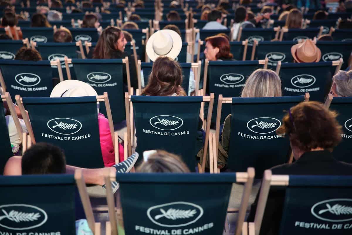 rear shot of people sitting in seats at the Cannes Film Festival seats facing the screen