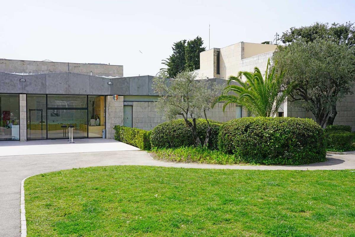 Exterior of modern museum with bushes and grass lawn in front