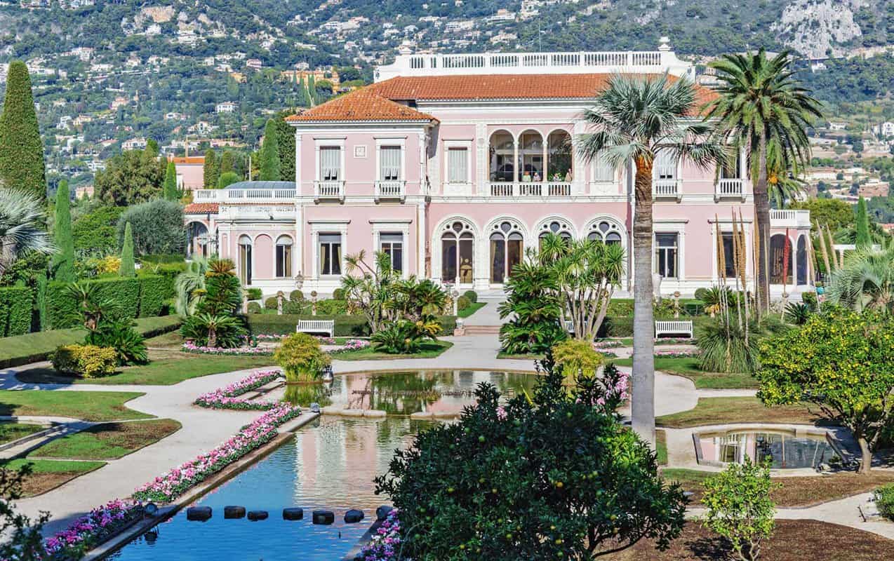 Stunning pink villa with lavish gardens including an ornamental pond in front