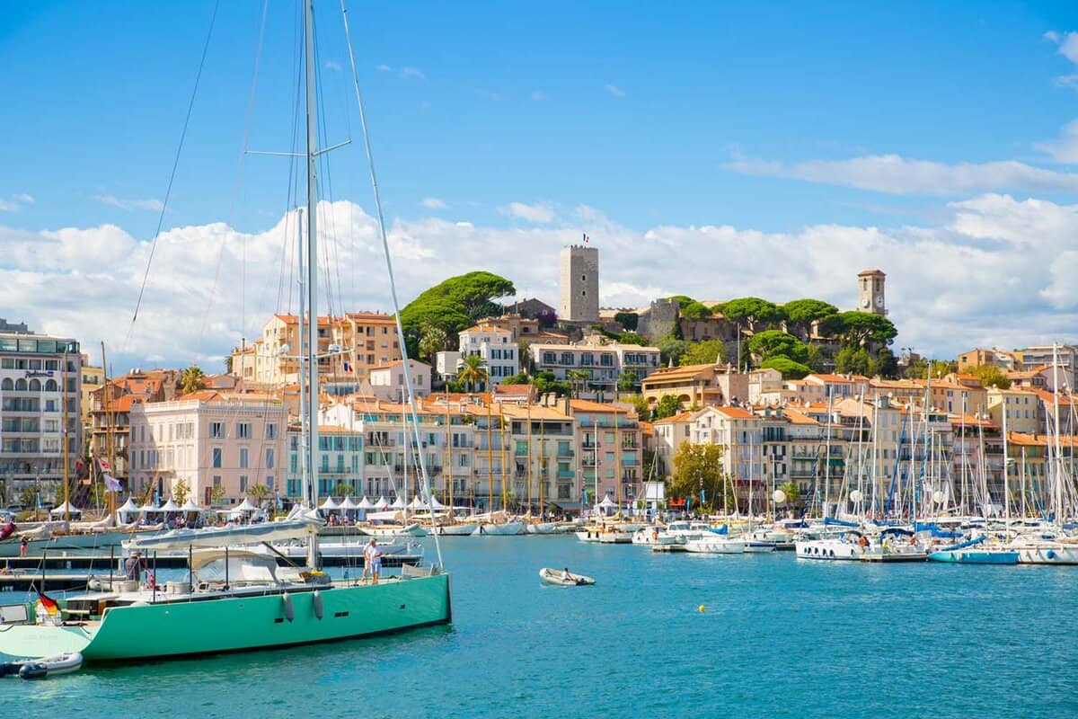 Yacht on blue sea in with seaside town in the background