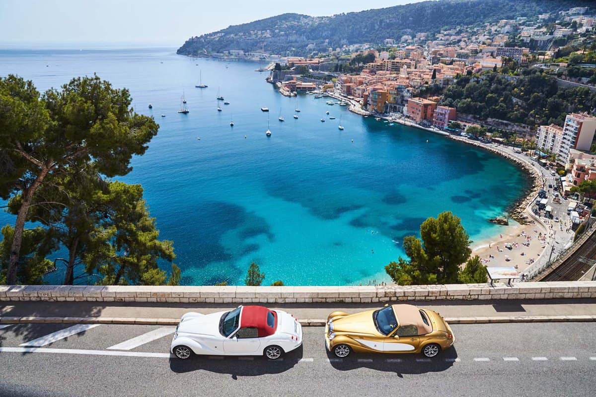 Classic cars parked on a seaside highway looking down on Villefranche Sur Mer