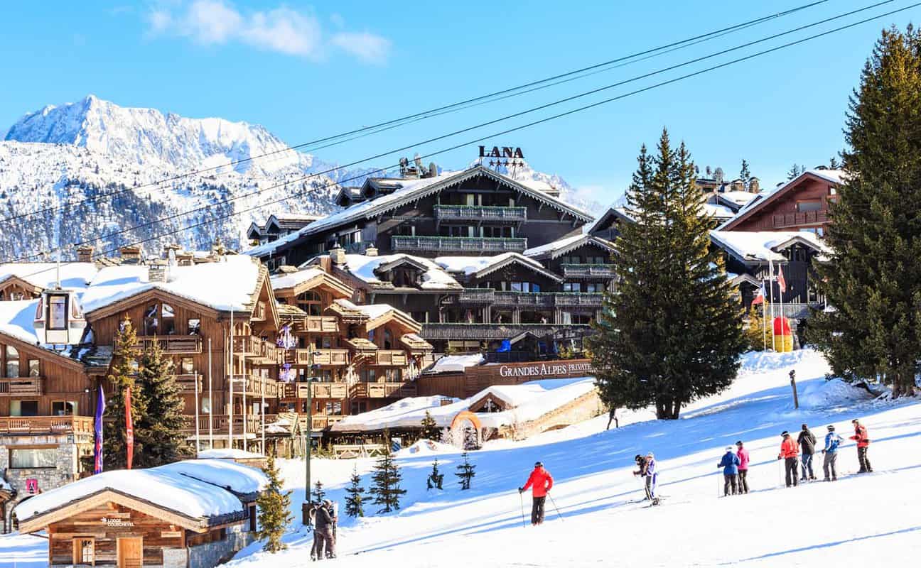 Ski Resort Courchevel 1850 m in wintertime. skiers stand on slope just outside the village at 1850