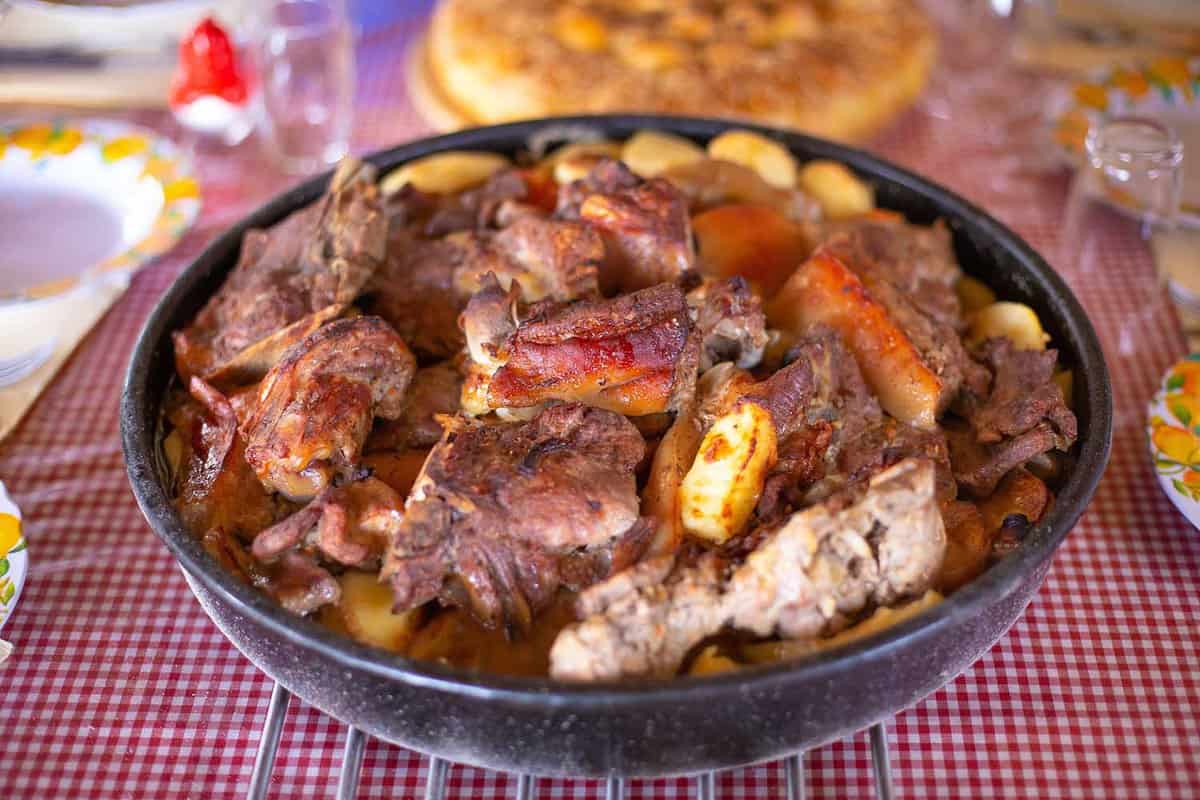 close up of a peka, a dish filled with cooked lamb pieces and vegetables