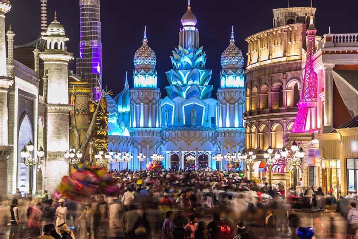 Colorful Entrance to Global Village with crowd in Dubai, UAE. Brightly colouredl lights and highly detailed pavilion facades have helped make Global Village one of Dubai's most popular attractions
