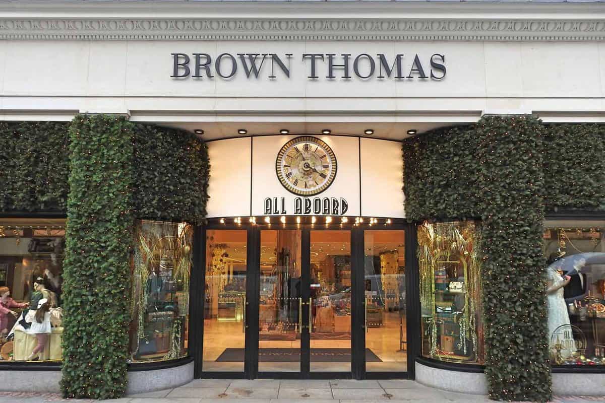 A festive Brown Thomas department store entrance with All Aboard signage and clock