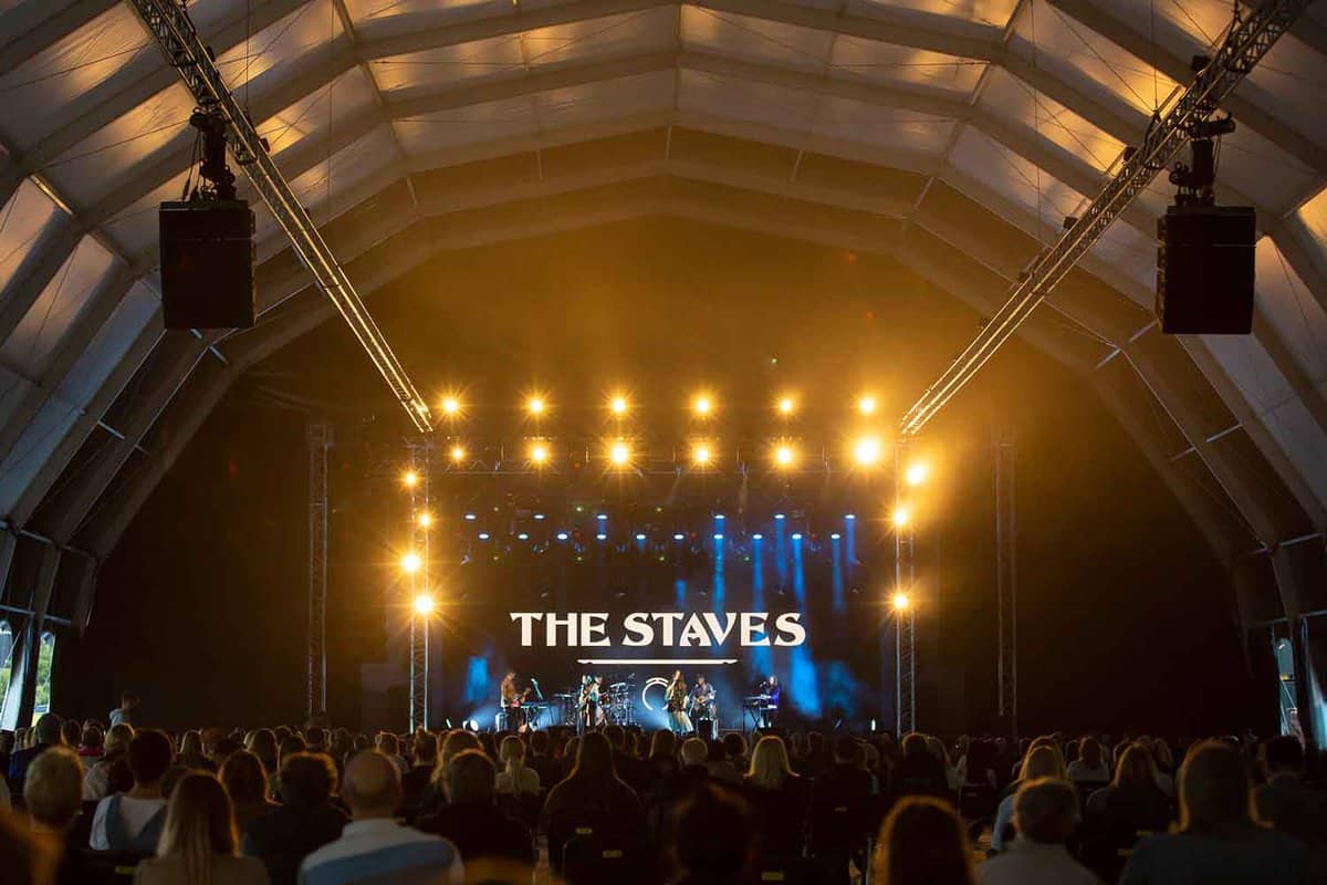 Stadium stage with a band playing on it called 'The Staves'