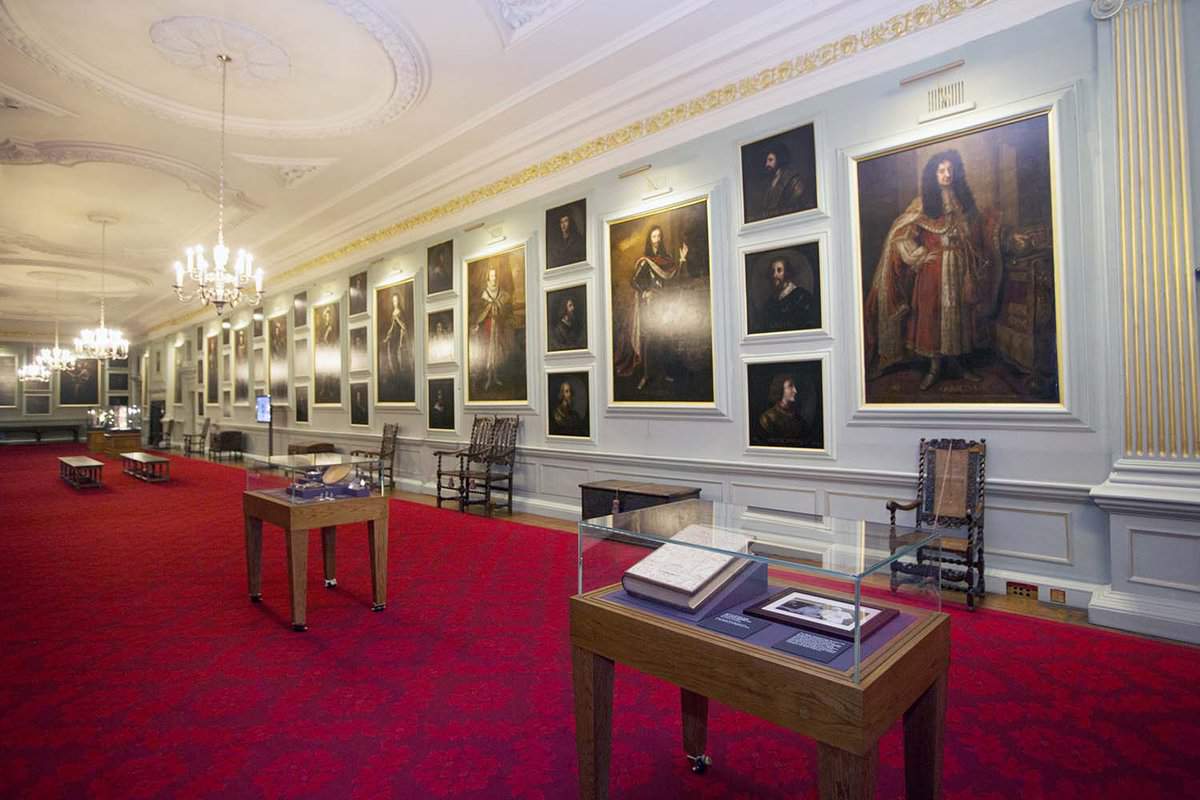 long hallway with red carpet and paintings on the wall