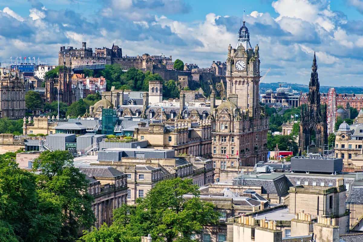 View of the city of Edinburgh in Scotland including several of its famous landmarks. Along with scatters of trees between the buildings