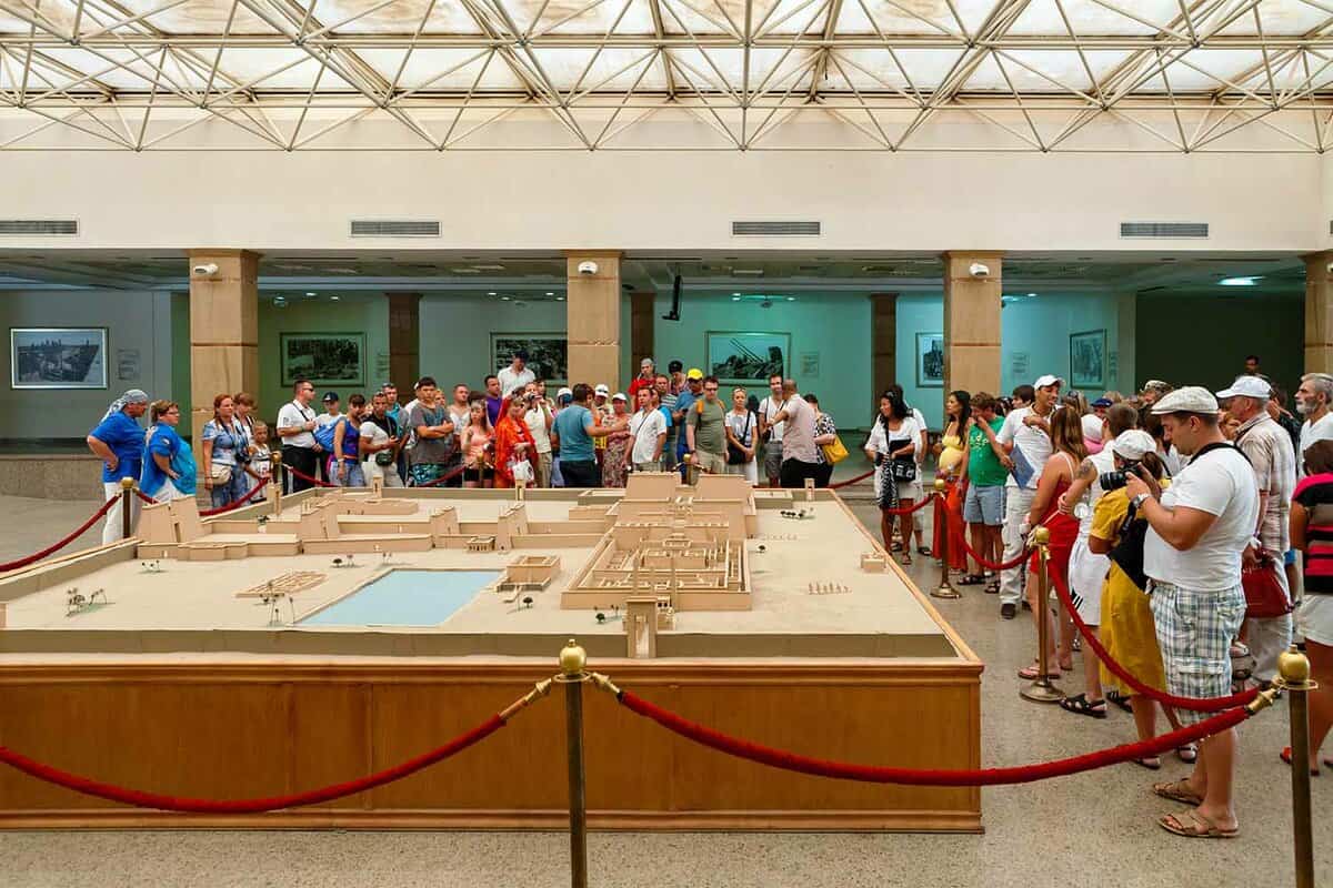 Tourists on a guided tour looking at temple complex model in Karnak Temple Visitor Centre