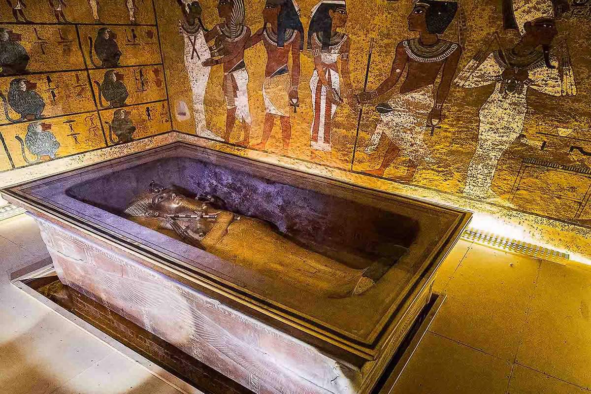 Looking down on an open sarcophagus containing the mummy of Tutankhamun