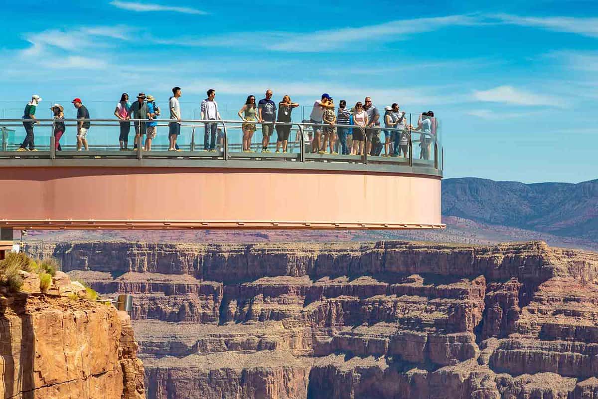 close up of the Skywalk, viewing platform jutting out over Grand Canyon with tourists on