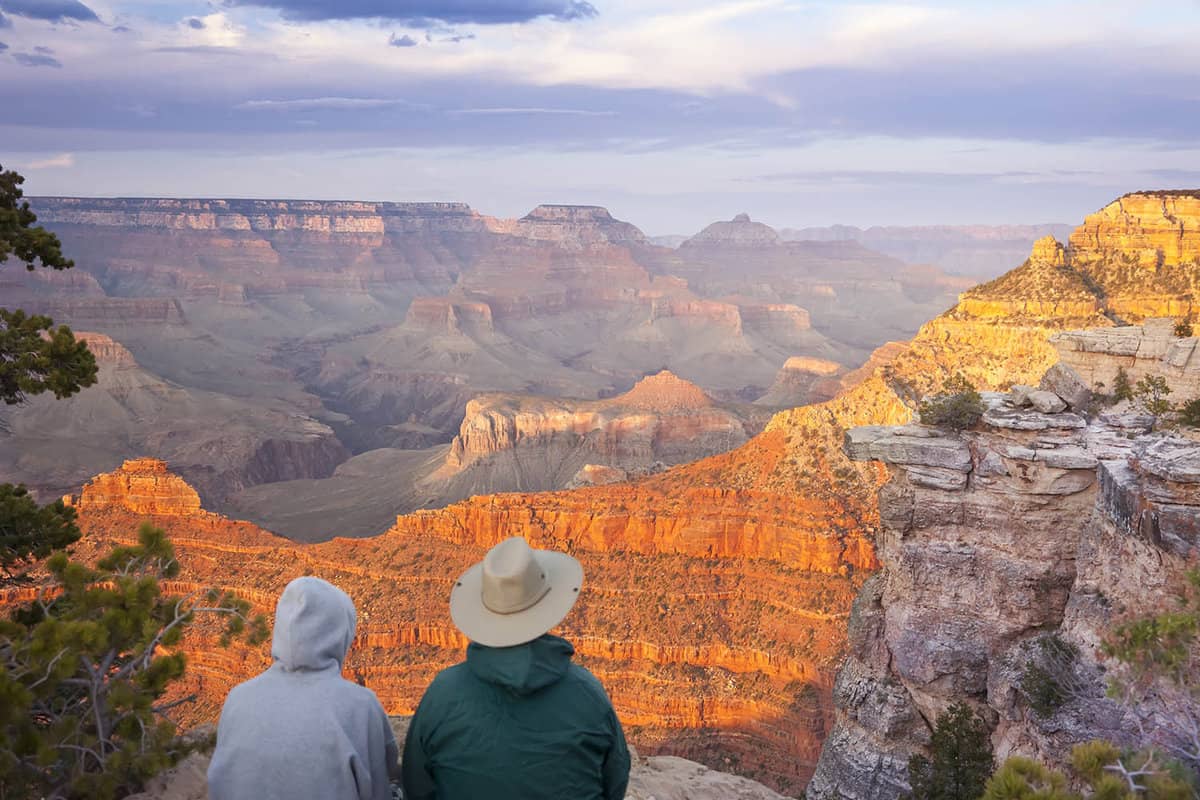 Couple staring out ovr the Grand Canyon from a viewpoint