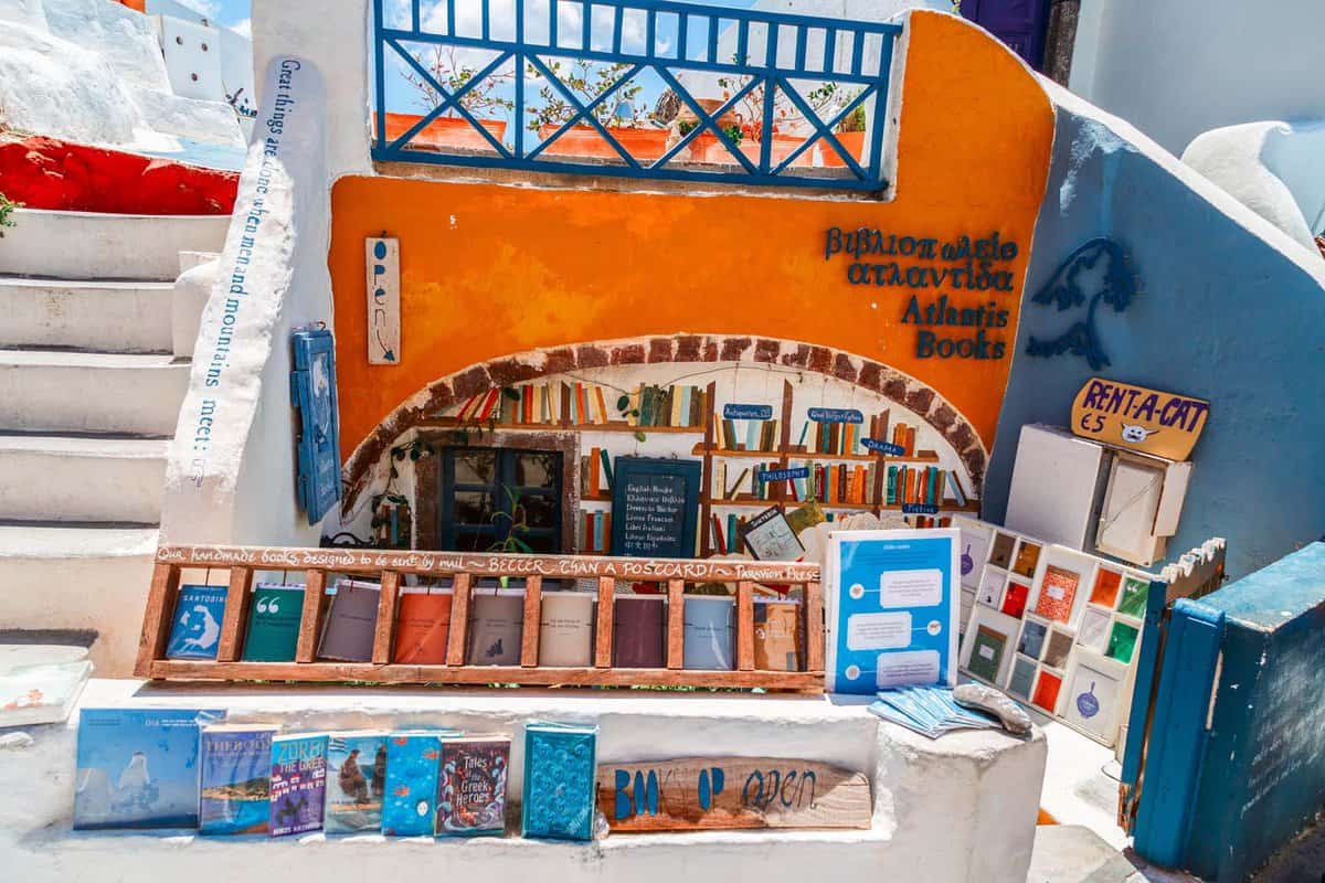 The bright warm orange and blue painted exterior of Atlantis bookshop, with books on display