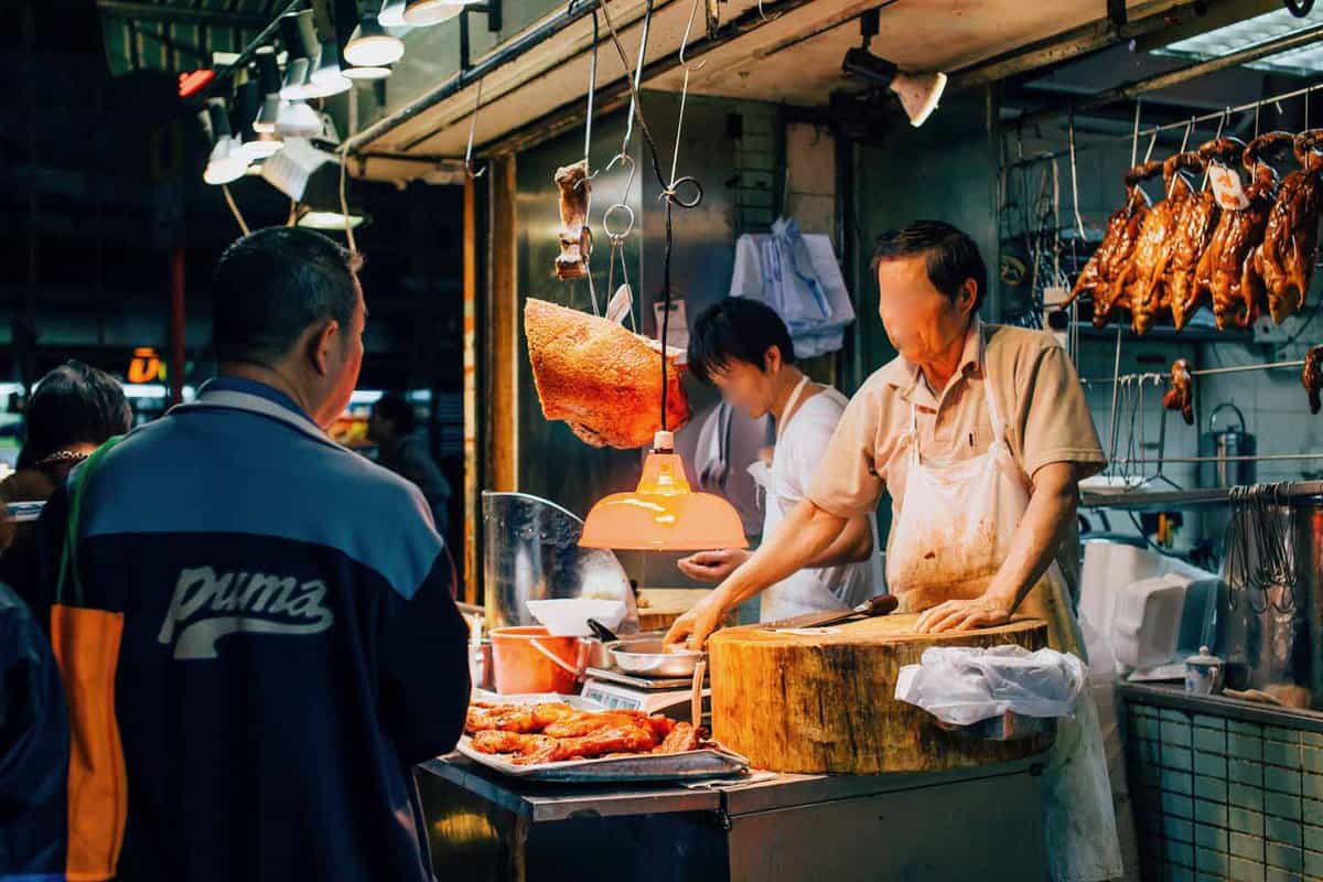 Vendors selling Peking duck at a night market