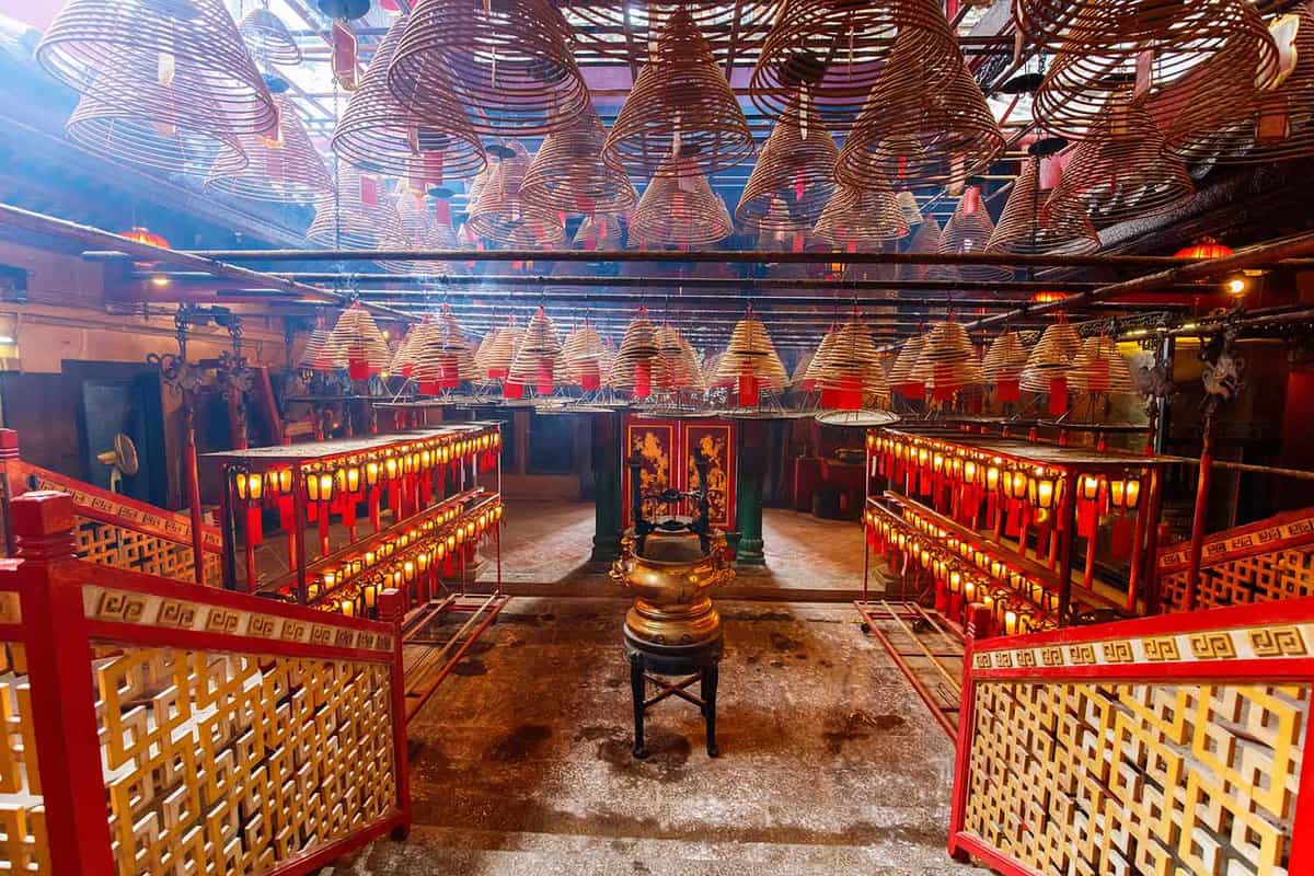 Interior of the temple, filled with lanterns, incense spirals, and bamboo beams