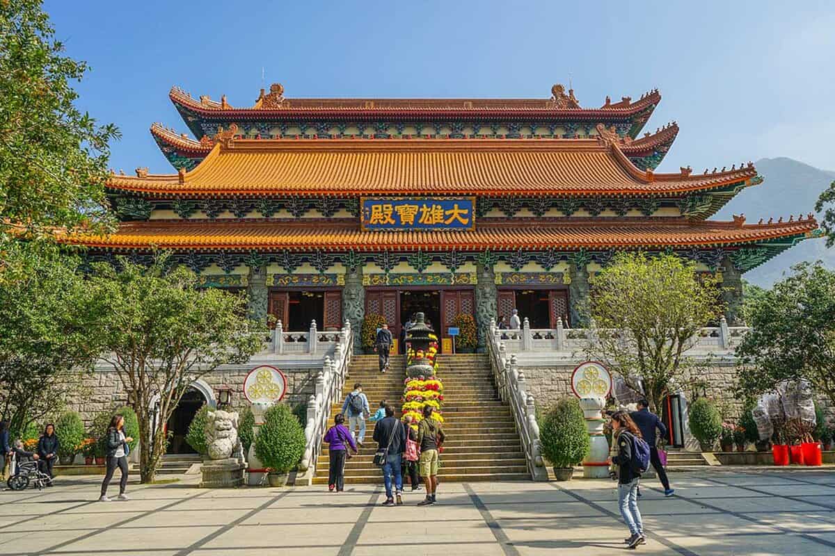 Exterior of a traditional Buddhist temple with people walking up the steps